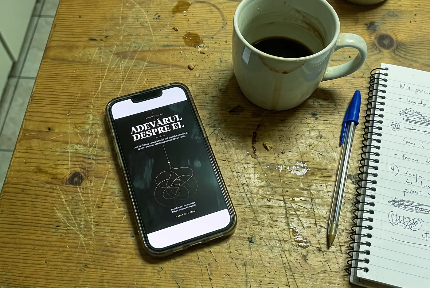 Cartea deschisă pe telefon, pe o masă de bucătărie